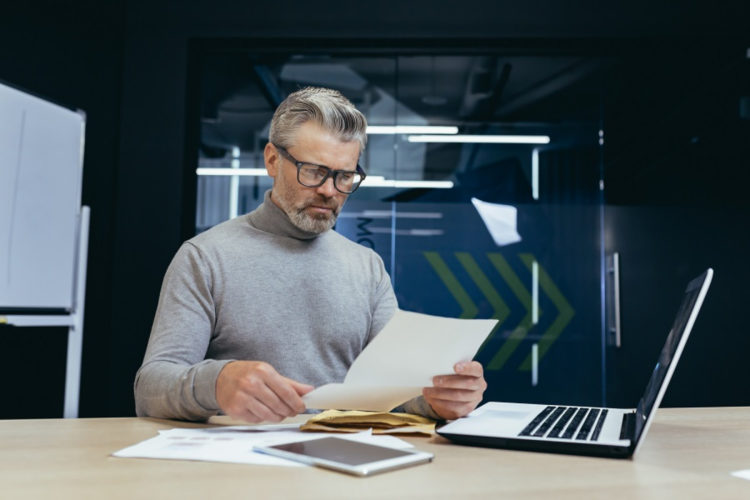 Cinquantenaire calculant ses remboursements de crédit