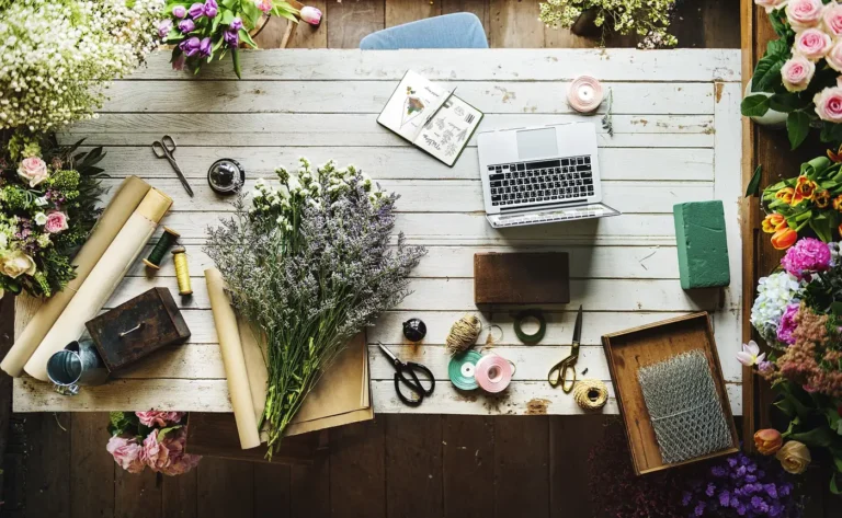 Table de travail d'une fleuriste avec bouquets et ordinateur portable